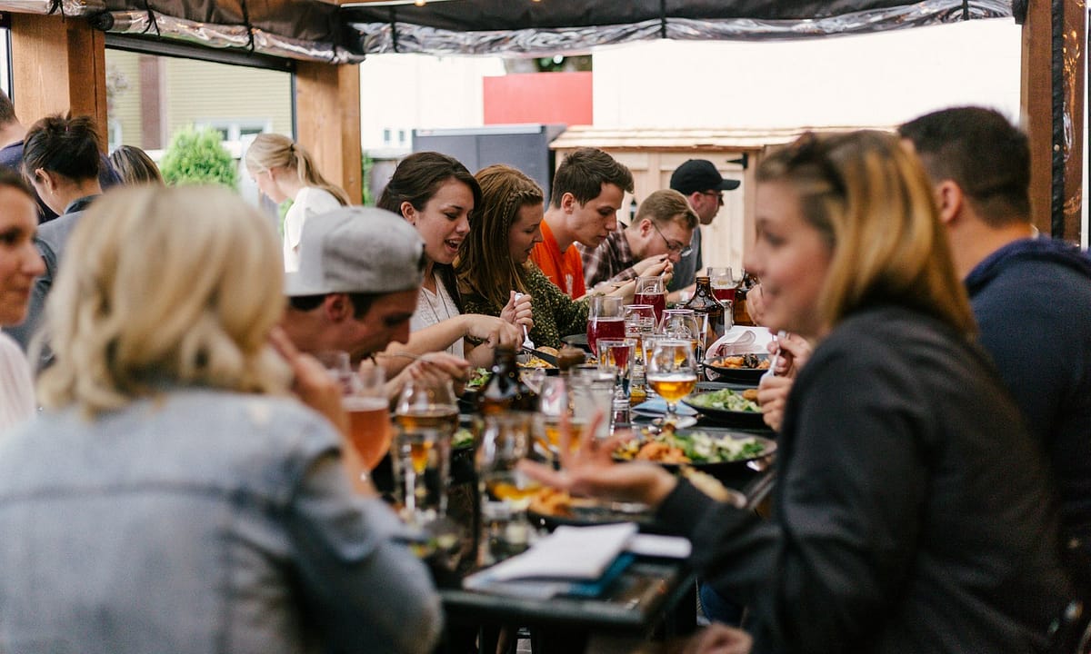 Hosté u společného stolu v restauraci