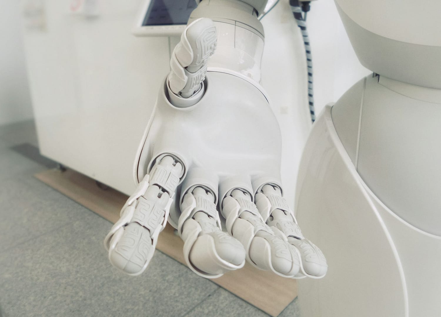 Bílé robotické rameno, ilustrace automatizace v gastronomii