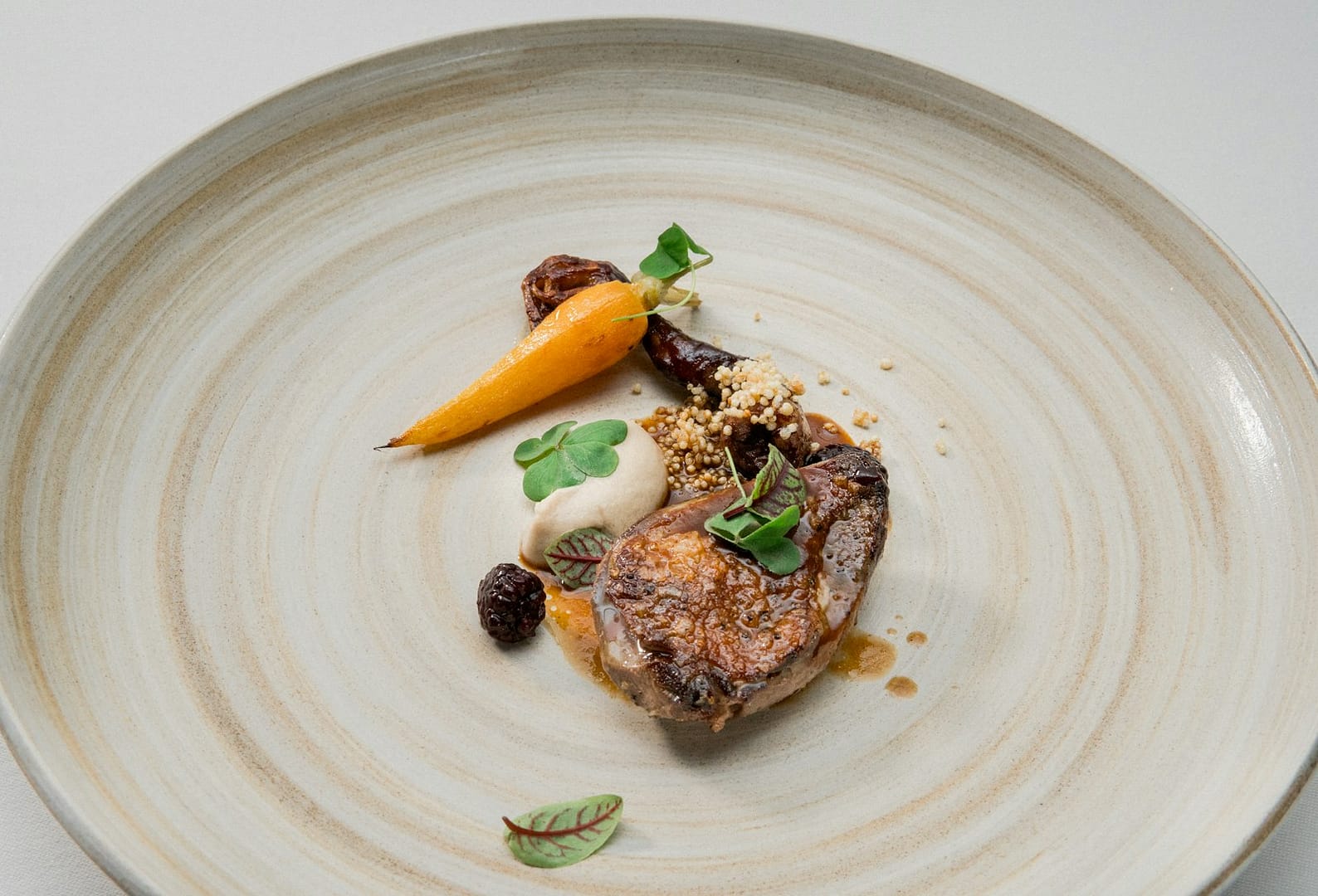 Servírovaný pokrm na bílém talíři v gurmánské restauraci