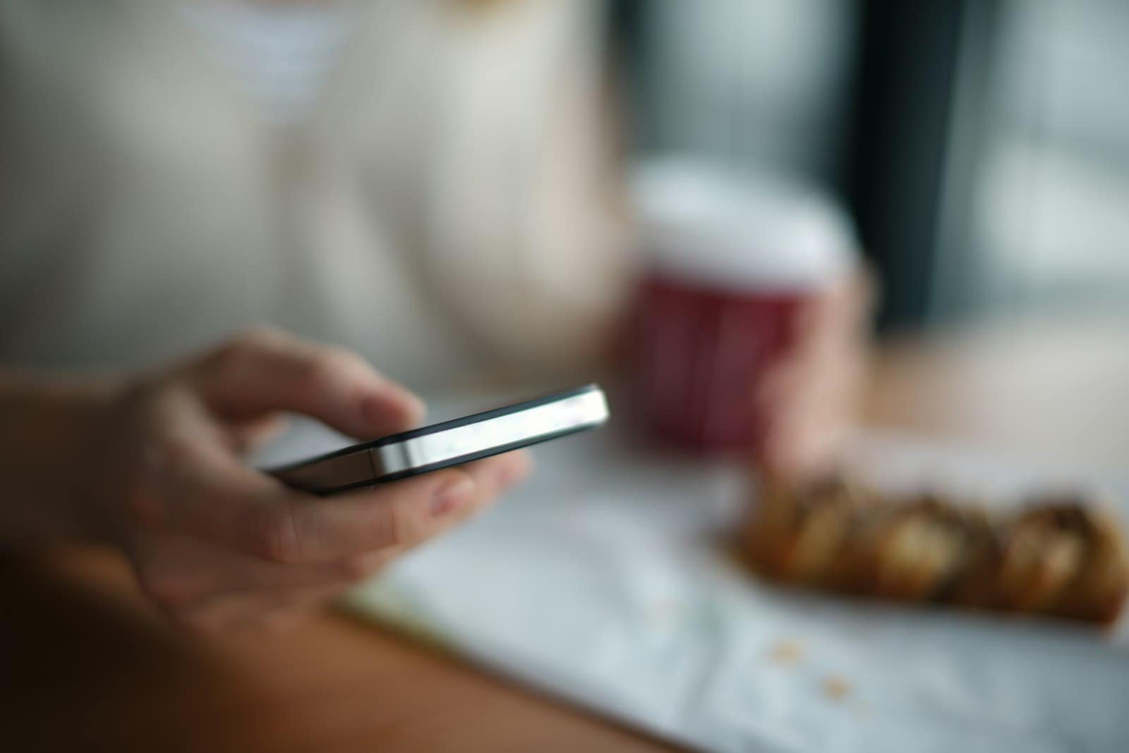 Host v kavárně s mobilním telefonem